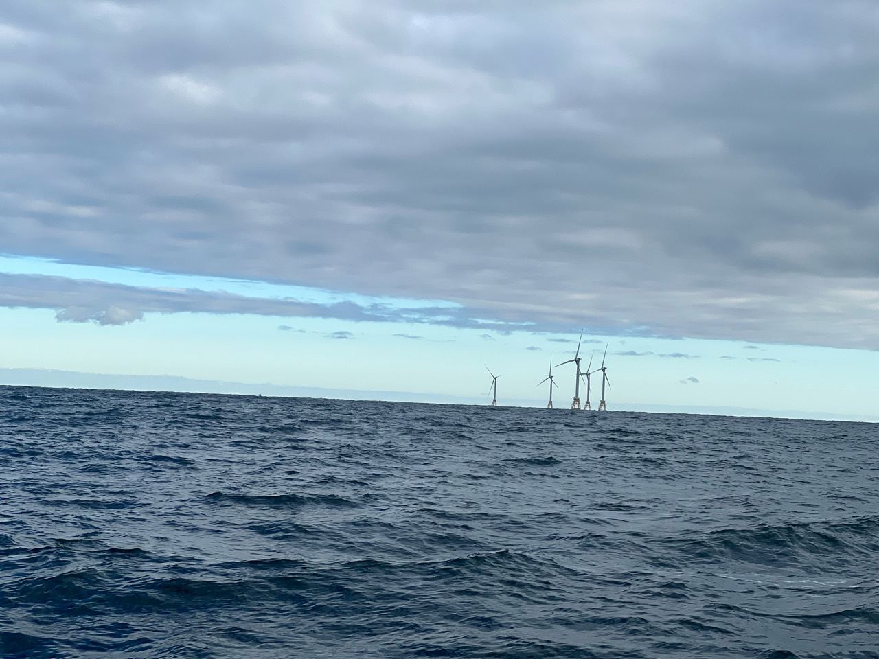 Eliot Fisher’s photograph of offshore wind turbines beneath a cloudy sky